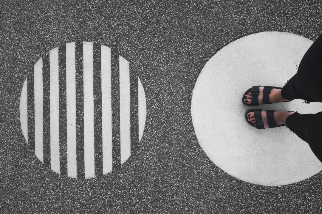 Photo of street with two circles, woman standing on one of them