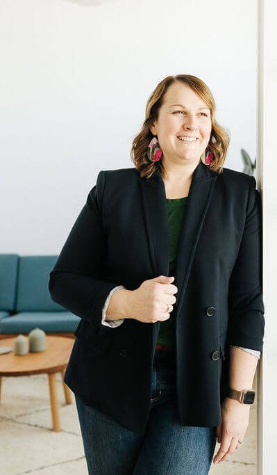 Lorissa Garcia is smiling, leaning against a white wall